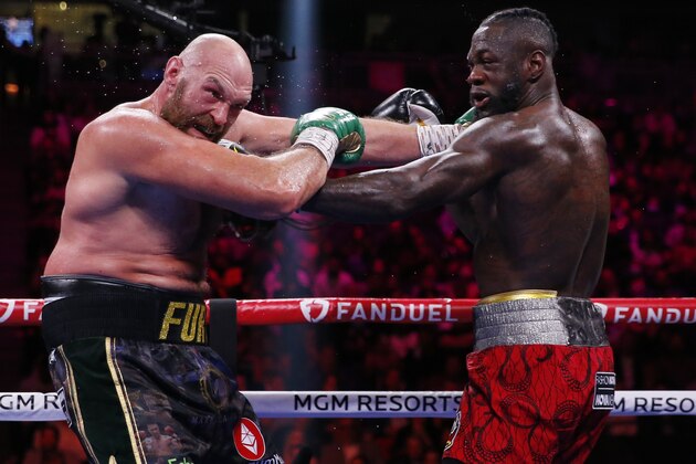 Tyson Fury, of England, left, fights Deontay Wilder in a heavyweight championship boxing match Saturday, Oct. 9, 2021, in Las Vegas. (AP Photo/Chase Stevens)