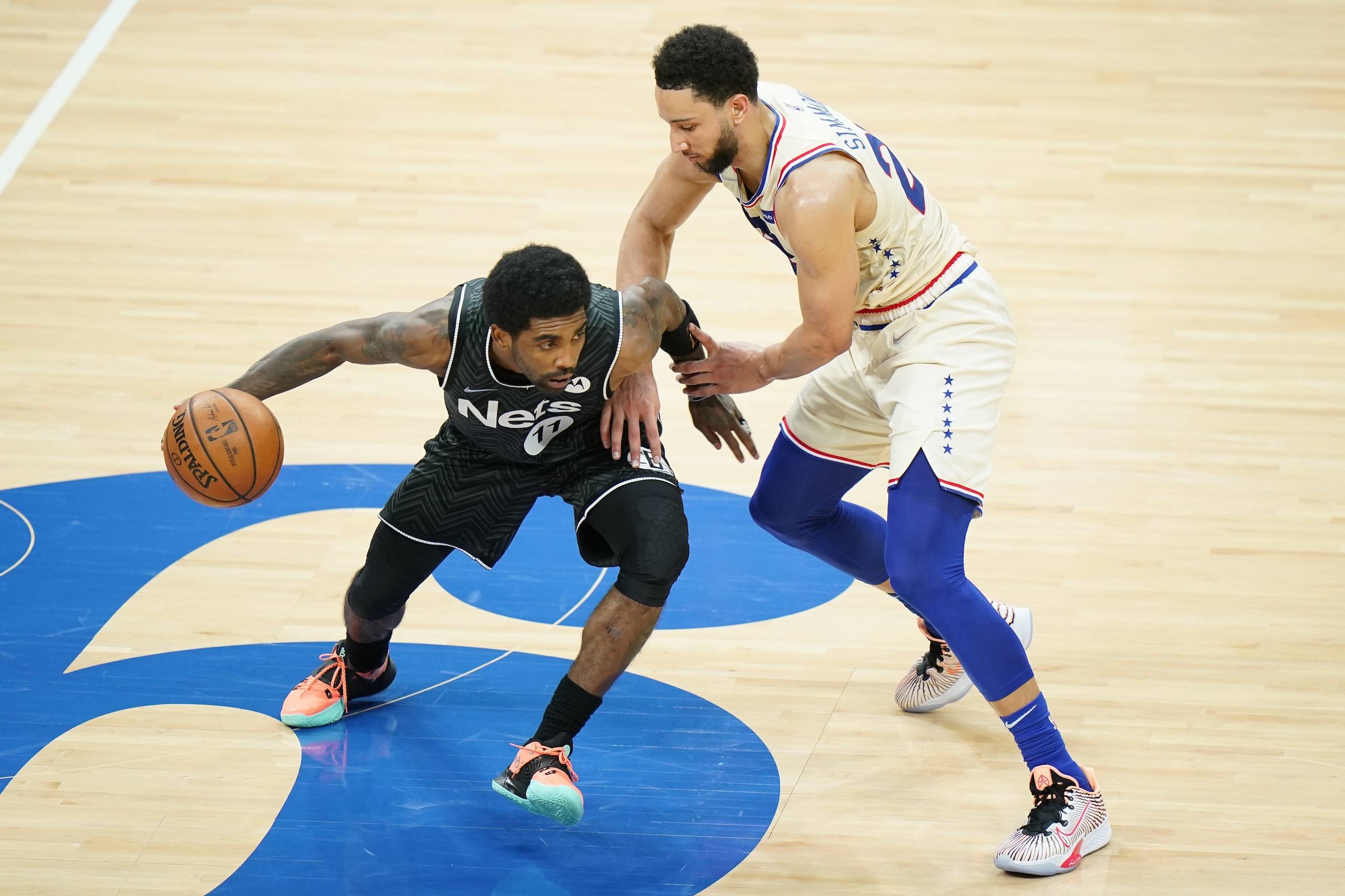 Brooklyn Nets' Kyrie Irving, left, tries to get past Philadelphia 76ers' Ben Simmons during the first half of an NBA basketball game, Wednesday, April 14, 2021, in Philadelphia. (AP Photo/Matt Slocum)