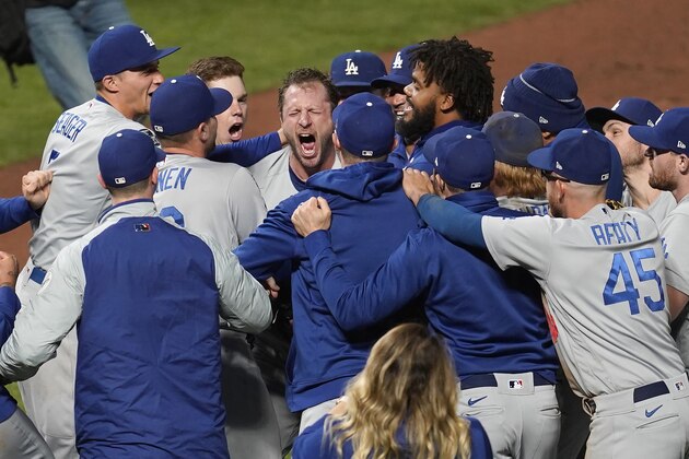 Los Angeles Dodgers pitcher Max Scherzer, center facing, celebrates with teammates after the Dodgers defeated the San Francisco Giants in Game 5 of a baseball National League Division Series Thursday, Oct. 14, 2021, in San Francisco. (AP Photo/Eric Risberg)