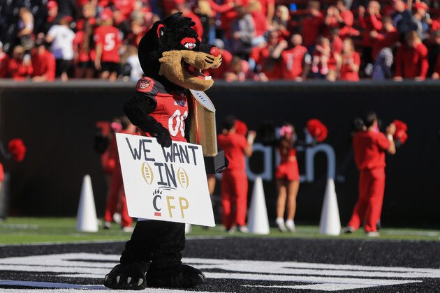 CINCINNATI, OH - OCTOBER 16: The Cincinnati Bearcats mascot holds up a replica of the National Championship trophy and a sign that reads