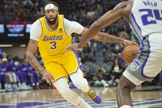 Los Angeles Lakers forward Anthony Davis (3) dribbles the ball past Sacramento Kings guard Buddy Hield (24) during the first quarter of an NBA basketball game in Sacramento, Calif., Thursday, Oct. 14, 2021. (AP Photo/Randall Benton)