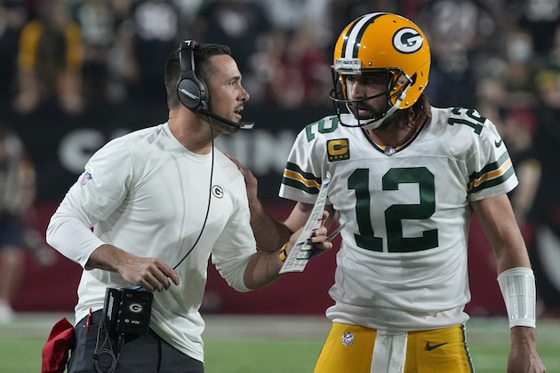 Green Bay Packers head coach Matt LaFleur talks with quarterback Aaron Rodgers (12) during the first half of an NFL football game against the Arizona Cardinals, Thursday, Oct. 28, 2021, in Glendale, Ariz. (AP Photo/Rick Scuteri)