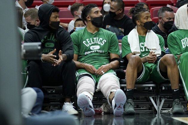Boston Celtics forward Jayson Tatum, sits with ice on his knees on t he bench with guard Marcus Smart, left, during the first half of a preseason NBA basketball game against the Miami Heat, Friday, Oct. 15, 2021, in Miami. (AP Photo/Lynne Sladky)
