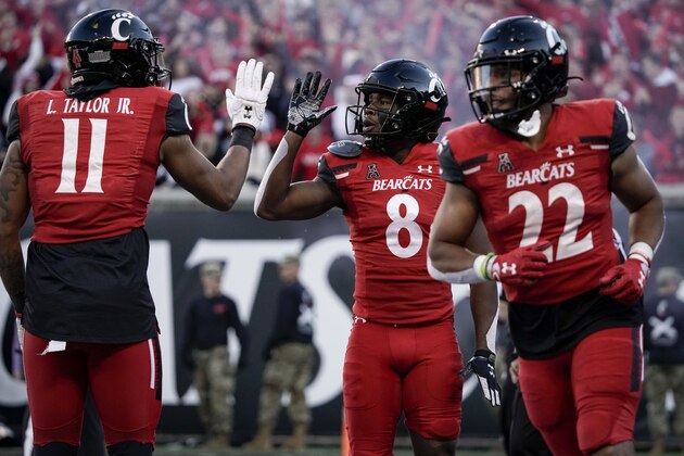 Cincinnati wide receiver Michael Young Jr. (8) celebrates with tight end Leonard Taylor (11) after scoring a touchdown during the second half of an NCAA college football game against Tulsa Saturday, Nov. 6, 2021, in Cincinnati. (AP Photo/Jeff Dean)