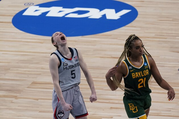 UConn guard Paige Bueckers (5) celebrates the team's win as Baylor guard DiJonai Carrington (21) walks off the court after a college basketball game in the Elite Eight round of the women's NCAA tournament at the Alamodome in San Antonio, Monday, March 29, 2021. (AP Photo/Eric Gay)