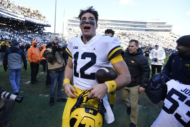 Michigan quarterback Cade McNamara (12) celebrates after defeating Penn State 21-17 in an NCAA college football game in State College, Pa., Saturday, Nov. 13, 2021. (AP Photo/Barry Reeger)