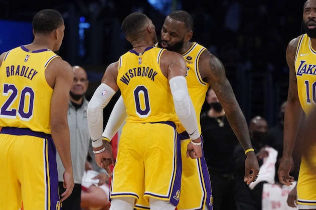 Los Angeles Lakers forward LeBron James, center right, bumps chest with guard Russell Westbrook (0) after James scored during the second half of an NBA basketball game against the Houston Rockets Tuesday, Nov. 2, 2021, in Los Angeles. (AP Photo/Marcio Jose Sanchez)