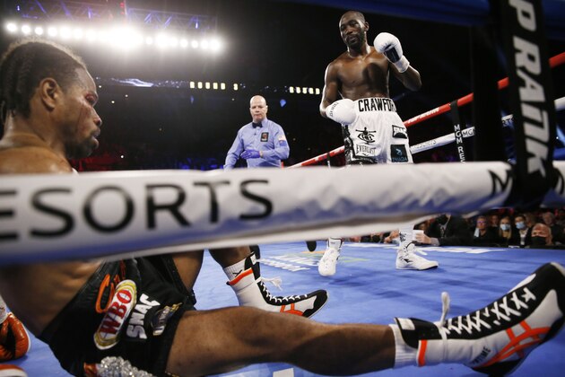 Terence Crawford knocks down Shawn Porter during a welterweight title boxing match Saturday, Nov. 20, 2021, in Las Vegas. (AP Photo/Chase Stevens)