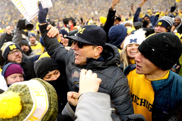 ANN ARBOR, MICHIGAN - NOVEMBER 27: Head Coach Jim Harbaugh of the Michigan Wolverines celebrates with fans after defeating the Ohio State Buckeyes at Michigan Stadium on November 27, 2021 in Ann Arbor, Michigan. (Photo by Mike Mulholland/Getty Images)