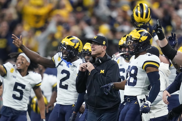 Michigan head coach Jim Harbaugh reacts with his players on the sideline during the second half of the Big Ten championship NCAA college football game against Iowa, Saturday, Dec. 4, 2021, in Indianapolis. (AP Photo/Darron Cummings)