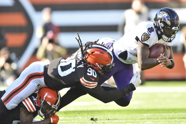 Cleveland Browns linebacker Jadeveon Clowney (90) tackles Baltimore Ravens quarterback Lamar Jackson (8) for no gain during the first half of an NFL football game, Sunday, Dec. 12, 2021, in Cleveland. (AP Photo/David Richard)