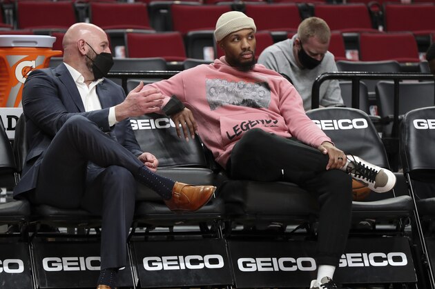 Portland Trail Blazers interim general manager Joe Cronin speaks with Portland Trail Blazers guard Damian Lillard prior to an NBA basketball game against the Miami Heat in Portland, Ore., Wednesday, Jan. 5, 2022. The Miami Heat won 115-109. (AP Photo/Amanda Loman)