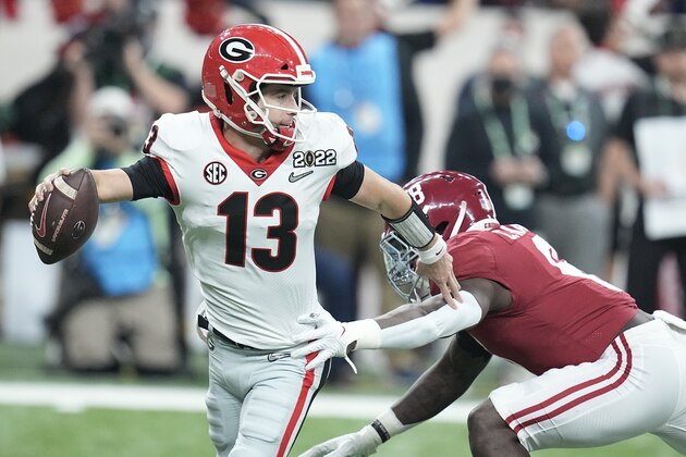 Georgia's Stetson Bennett gets away from Alabama's Christian Harris during the first half of the College Football Playoff championship football game Monday, Jan. 10, 2022, in Indianapolis. (AP Photo/Darron Cummings)