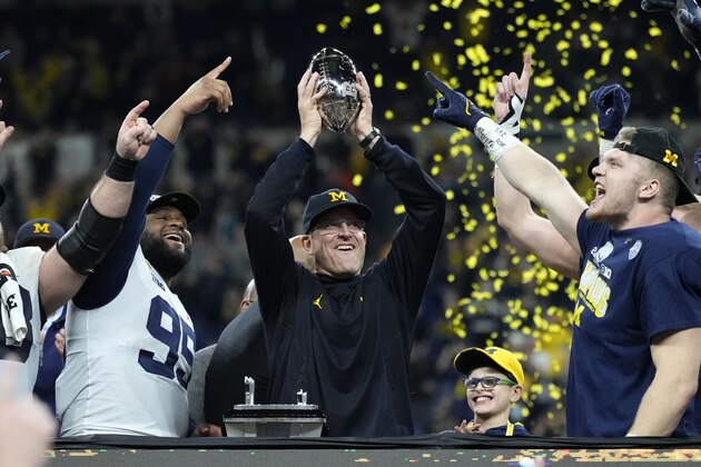 Michigan head coach Jim Harbaugh celebrates with his team after the Big Ten championship NCAA college football game against Iowa, Saturday, Dec. 4, 2021, in Indianapolis. Michigan won 42-3. (AP Photo/AJ Mast)