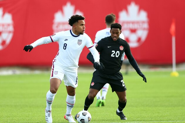 HAMILTON, ON - JANUARY 30:  Weston McKennie #8 of the United States and Jonathan David #20 of Canada battle for the ball during a 2022 World Cup Qualifying match at Tim Hortons Field on January 30, 2022 in Hamilton, Ontario, Canada.  (Photo by Vaughn Ridley/Getty Images)