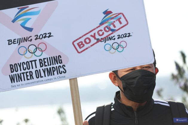 SAUSALITO, CALIFORNIA - FEBRUARY 03: A protester holds a sign before marching across the Golden Gate Bridge during a demonstration against the 2022 winter Olympic Games that are being held in China on February 03, 2022 in Sausalito, California. Dozens of Tibetan and human rights activists staged a protest at the Golden Gate Bridge to demand that people boycott the 2022 Winter Olympic Games from Beijing, China due to the country's human rights abuses. (Photo by Justin Sullivan/Getty Images)