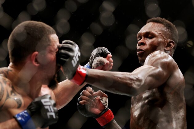HOUSTON, TEXAS - FEBRUARY 12: Israel Adesanya of Nigeria punches Robert Whittaker of Australia in their middleweight championship fight during UFC 271 at Toyota Center on February 12, 2022 in Houston, Texas. (Photo by Carmen Mandato/Getty Images)