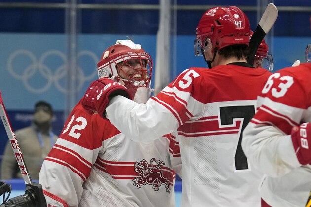 Denmark goalkeeper Sebastian Dahm (32) is congratulated after a win over Czech Republic during a preliminary round men's hockey game at the 2022 Winter Olympics, Wednesday, Feb. 9, 2022, in Beijing. (AP Photo/Petr David Josek)
