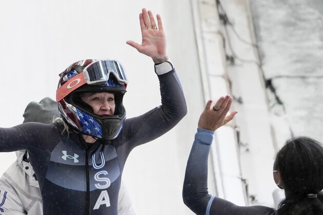 Kaillie Humphries, of the United States, left, celebrates with teammate Elana Meyers Taylor, winning the gold medal in the women's monobob at the 2022 Winter Olympics, Monday, Feb. 14, 2022, in the Yanqing district of Beijing. (AP Photo/Pavel Golovkin)
