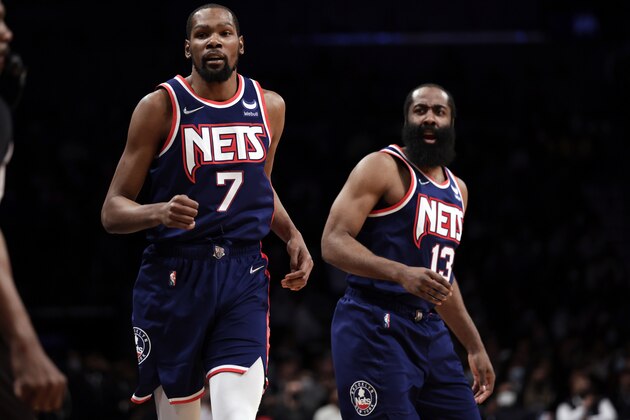 Brooklyn Nets forward Kevin Durant (7) and James Harden react against the Milwaukee Bucks during the first half of an NBA basketball game Friday, Jan. 7, 2022, in New York. (AP Photo/Adam Hunger)