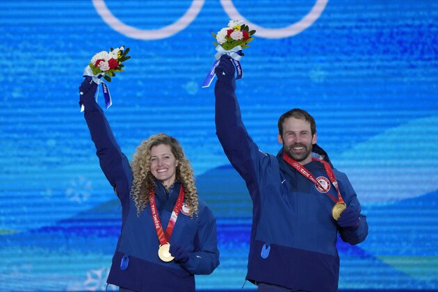 Gold medalists United States' Lindsey Jacobellis and Nick Baumgartner celebrates during a medal ceremony for the mixed team snowboard cross at the 2022 Winter Olympics, Saturday, Feb. 12, 2022, in Zhangjiakou, China. (AP Photo/Lee Jin-man)