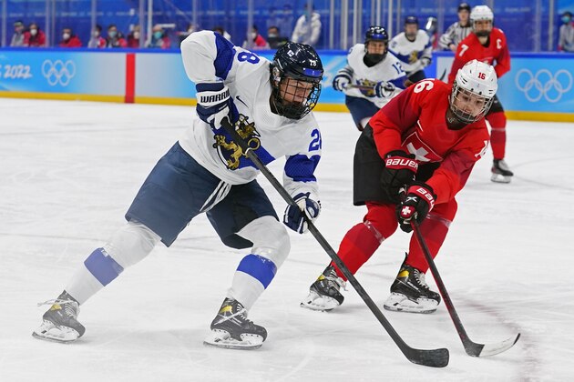 Finland's Jenniina Nylund (28) moves the puck against Switzerland's Nicole Vallario (16) during a preliminary round women's hockey game at the 2022 Winter Olympics, Monday, Feb. 7, 2022, in Beijing. (AP Photo/Matt Slocum)