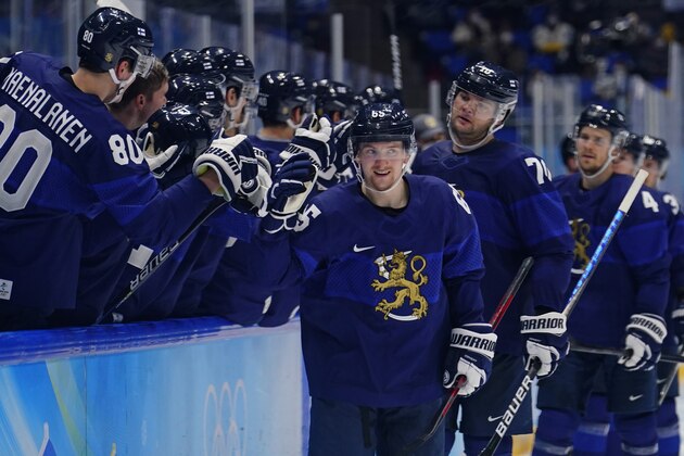 Finland's Sakari Manninen (65) is congratulated after scoring his third goal of the game during a preliminary round men's hockey game against Slovakia at the 2022 Winter Olympics, Thursday, Feb. 10, 2022, in Beijing. (AP Photo/Matt Slocum)
