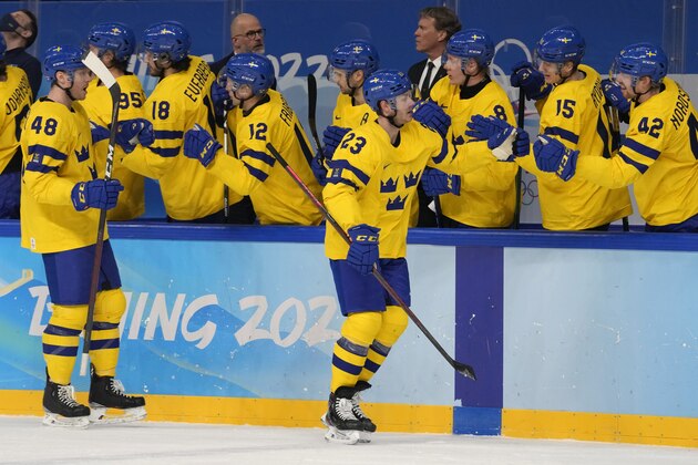 Sweden's Lucas Wallmark (23) celebrates his goal with teammates against Slovakia during a preliminary round men's hockey game at the 2022 Winter Olympics, Friday, Feb. 11, 2022, in Beijing. (AP Photo/Petr David Josek)