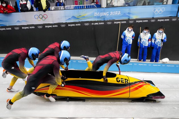 Francesco Friedrich, Thorsten Margis, Candy Bauer and Alexander Schueller, of Germany, start the 4-man heat 2 at the 2022 Winter Olympics, Saturday, Feb. 19, 2022, in the Yanqing district of Beijing. (AP Photo/Dmitri Lovetsky)