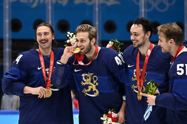 Finland's Hannes Bjorninen (L) and Finland's Petteri Lindbohm (2L) and Finland's Valtteri Filppula (R)  celebrate with their gold medals after the men's gold medal match of the Beijing 2022 Winter Olympic Games ice hockey competition between Finland and Russia's Olympic Committee, at the National Indoor Stadium in Beijing on February 20, 2022. (Photo by ANTHONY WALLACE / AFP) (Photo by ANTHONY WALLACE/AFP via Getty Images)