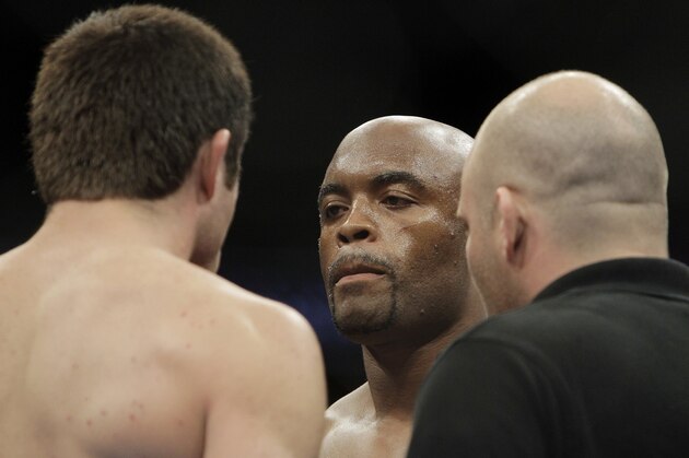 Anderson Silva, center, reacts during a UFC mixed martial arts match against Chael Sonnen, left, in Oakland, California, Saturday, August 7, 2010. Silva won by submission in the fifth round to retain the championship. (AP Photo/Jeff Chiu)