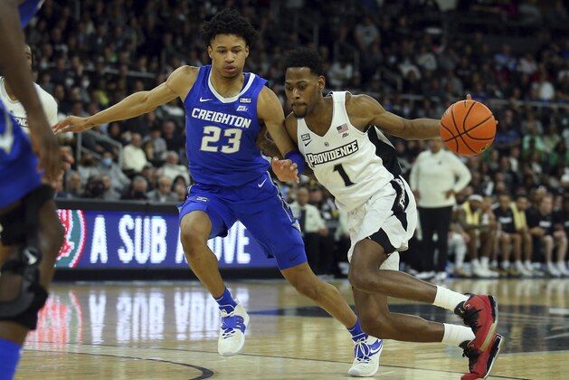 Providence's Al Durham (1) is defended by Creighton's Trey Alexander (23) during the first half of an NCAA college basketball game Saturday, Feb. 26, 2022, in Providence, R.I. (AP Photo/Stew Milne)