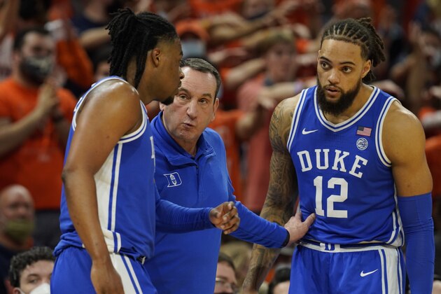 Duke head coach Mike Krzyzewski, center, talks with guard Trevor Keels, left, and Theo John during the first half of an NCAA college basketball game against Virginia Wednesday Feb. 23, 2022, in Charlottesville, Va. (AP Photo/Steve Helber)
