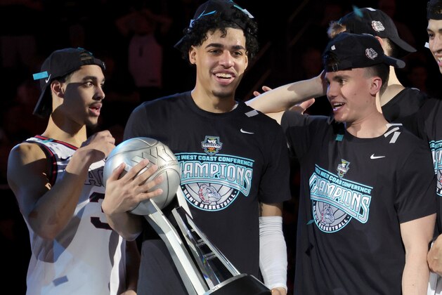 LAS VEGAS, NEVADA - MARCH 08: (L-R) Andrew Nembhard #3, Julian Strawther #0 and Matthew Lang #23 of the Gonzaga Bulldogs celebrate with the championship trophy after the team's 82-69 victory over the Saint Mary's Gaels to win the championship game of the West Coast Conference basketball tournament at the Orleans Arena on March 08, 2022 in Las Vegas, Nevada. (Photo by Ethan Miller/Getty Images)
