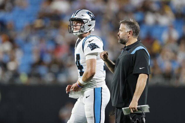 Carolina Panthers head coach Matt Rhule, right, talks to quarterback Sam Darnold during the first half of a preseason NFL football game against the Pittsburgh Steelers Friday, Aug. 27, 2021, in Charlotte, N.C. (AP Photo/Nell Redmond)