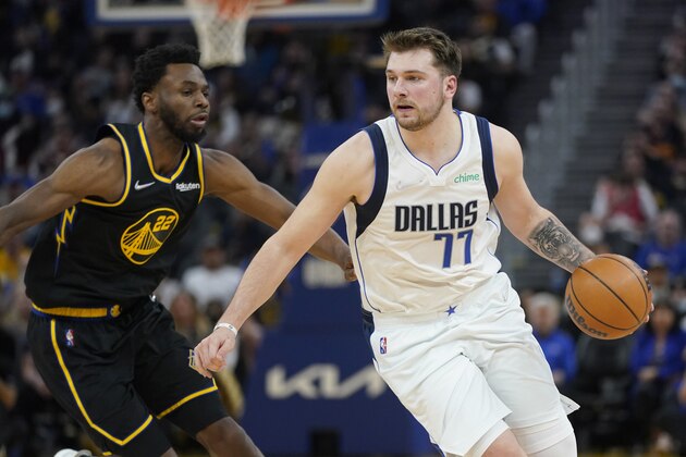 Dallas Mavericks guard Luka Doncic (77) drives to the basket against Golden State Warriors forward Andrew Wiggins during an NBA basketball game in San Francisco, Sunday, Feb. 27, 2022. (AP Photo/Jeff Chiu)