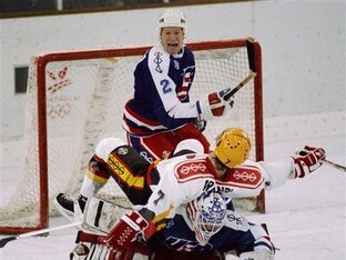 U.S. goalkeeper Ray LeBlanc from Fitchburg, Mass., shown lying under Germany’s Thomas Brandl, saves the puck in Tuesday’s Olympic ice hockey game, Feb. 11, 1992, Meribel, France. The USA won 2-0 as LeBlanc kept his goal clean in the first shutout for a U.