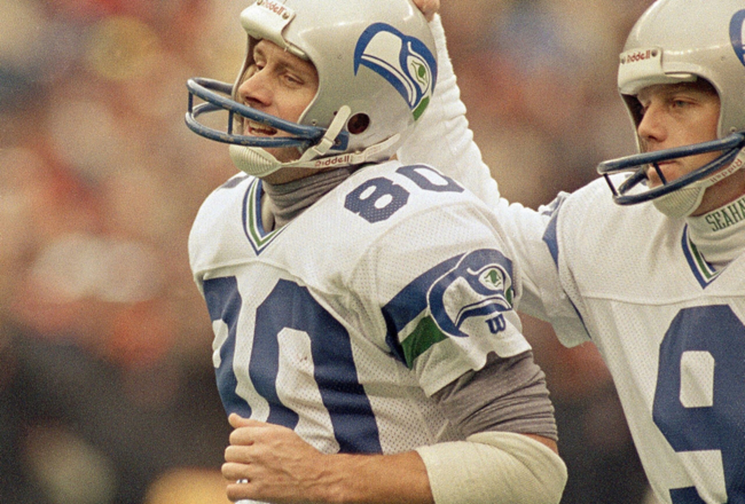 Seattle Seahawks receiver Steve Largent (80) gets a pat on the helmet from teammate Norm Johnson after Largent caught his 100th career touchdown pass against the Cincinnati Bengals at Riverfront Stadium in Cincinnati, Dec. 10, 1989. Largent broke the 44-y