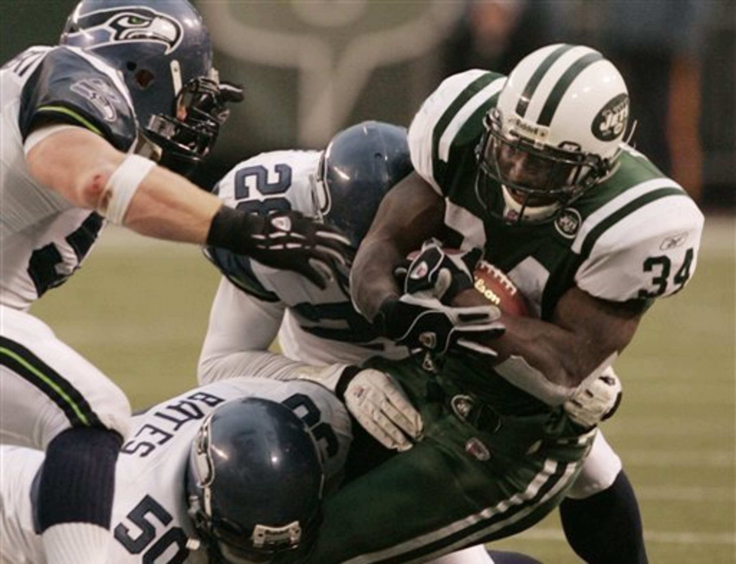 New York Jets runningback LaMont Jordan is brought down by Seattle Seahawks' Solomon Bates and  Michael Boulware as Isaiah Kacyvenski moves in to help during the fourth quarter Sunday, Dec. 19, 2004 in East Rutherford, New Jersey. Jordan rushed for 84 yar