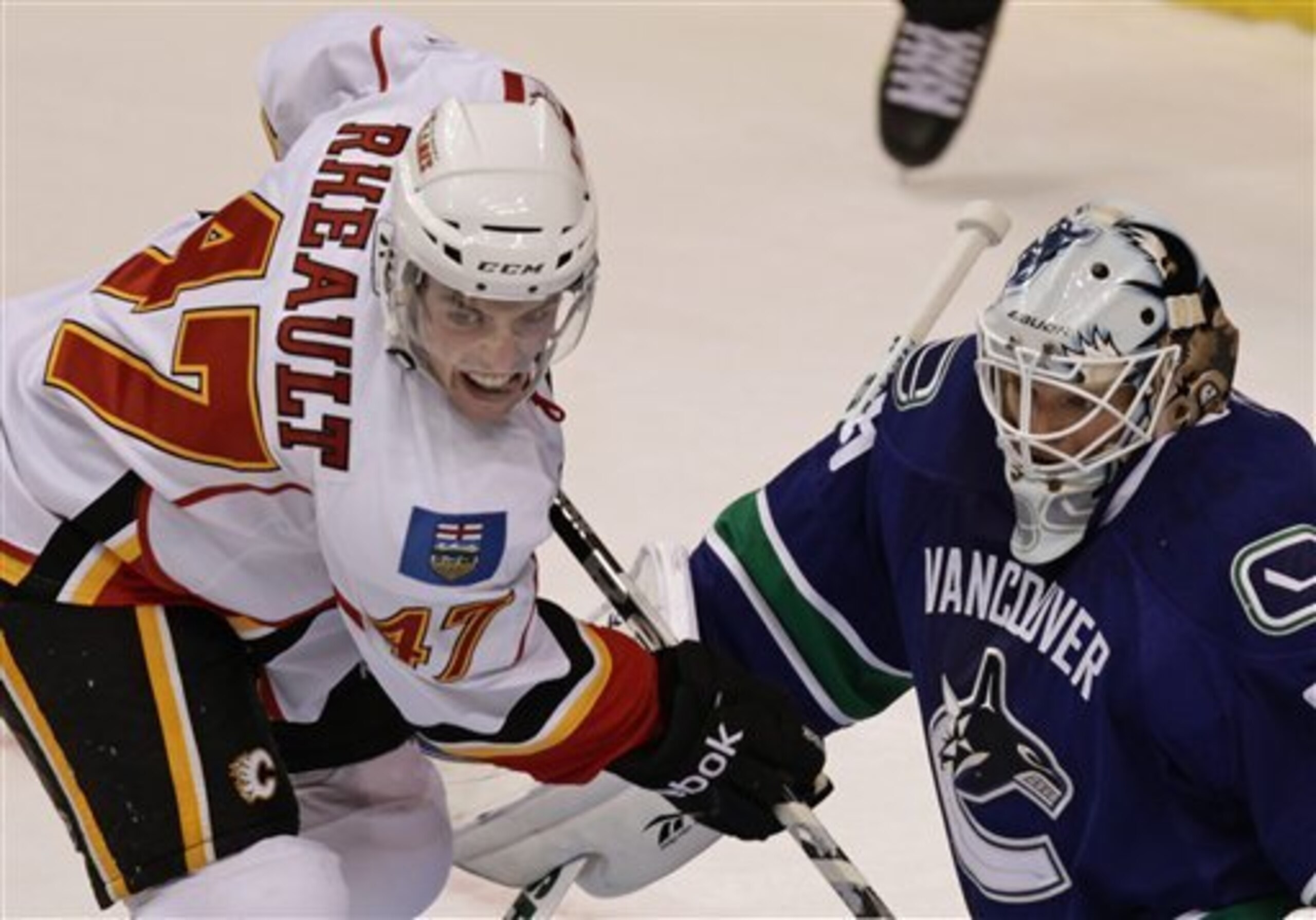 Calgary Flames' Jon Rheault, left, and Vancouver Canucks' Cory Schneider follow the puck during first period pre-season NHL hockey action in Vancouver, B.C., on Tuesday September 21, 2010. The teams are playing two split-squad games with one game in Vanco Calgary Flames' Jon Rheault, left, and Vancouver Canucks' Cory Schneider follow the puck during first period pre-season NHL hockey action in Vancouver, B.C., on Tuesday September 21, 2010. The teams are playing two split-squad games with one game in Vanco