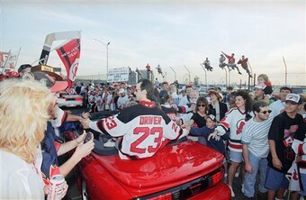 New Jersey Devils Bruce Driver reaches out to fans during a motorcade around the Meadowlands Arena in East Rutherford, N.J., to celebrate the Stanley Cup champions on Wednesday, June 28, 1995. (AP Photo/Mike Derer)