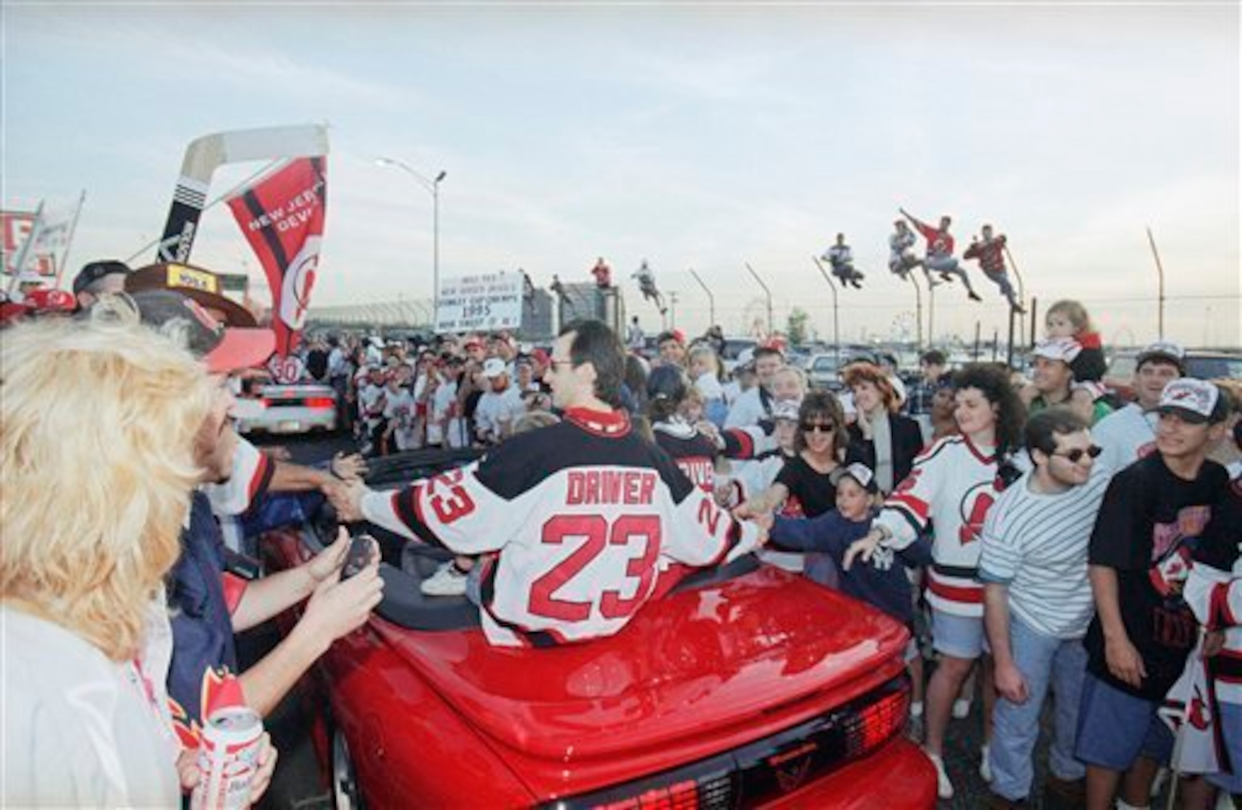 New Jersey Devils Bruce Driver reaches out to fans during a motorcade around the Meadowlands Arena in East Rutherford, N.J., to celebrate the Stanley Cup champions on Wednesday, June 28, 1995. (AP Photo/Mike Derer)