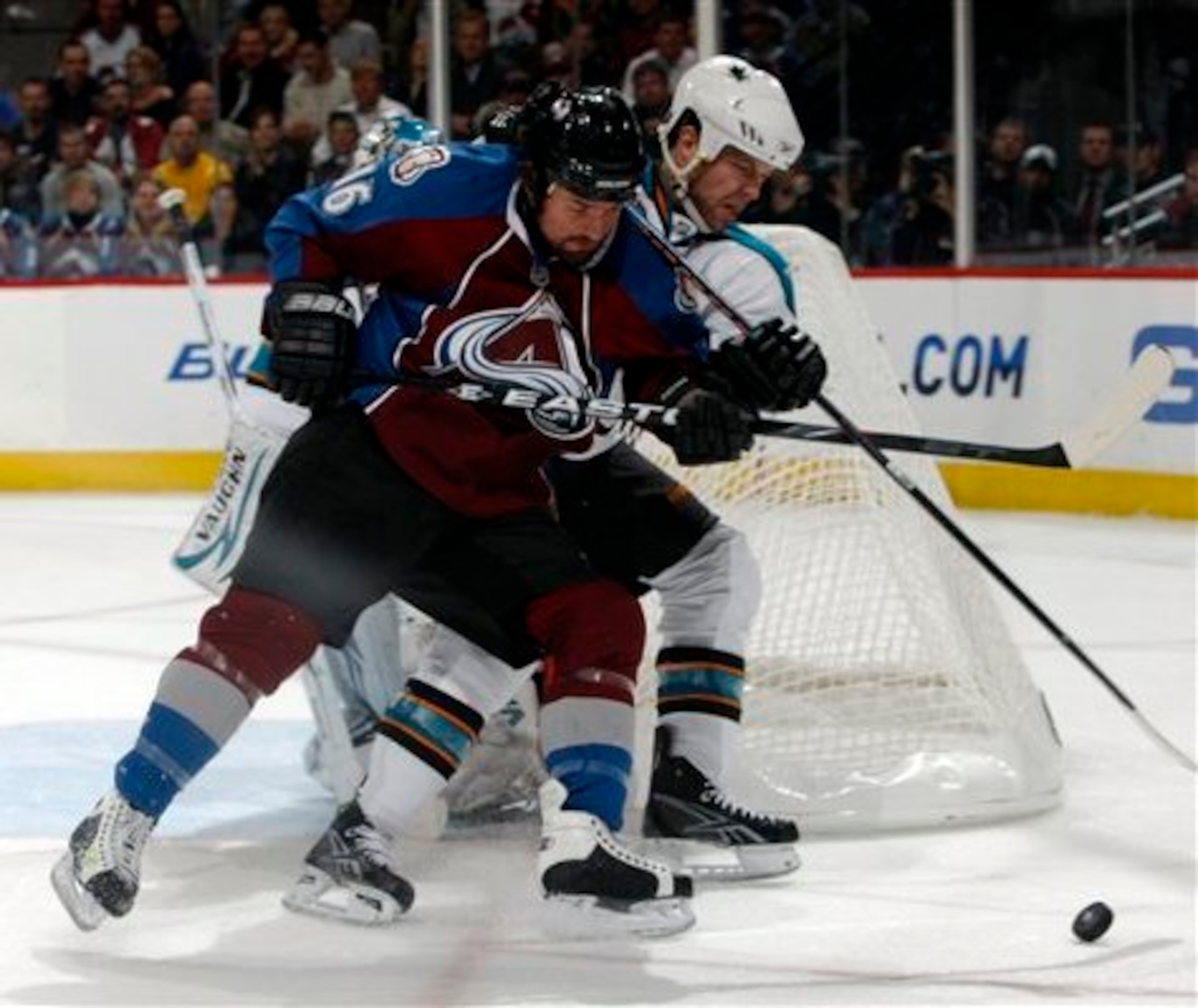 Colorado Avalanche right winger Darcy Tucker, front, struggles to shoot the puck as San Jose Sharks defenseman Kent Huskins covers in the third period of Game 4 of the teams' NHL Western Conference first-round playoff series in Denver on Tuesday, April 20