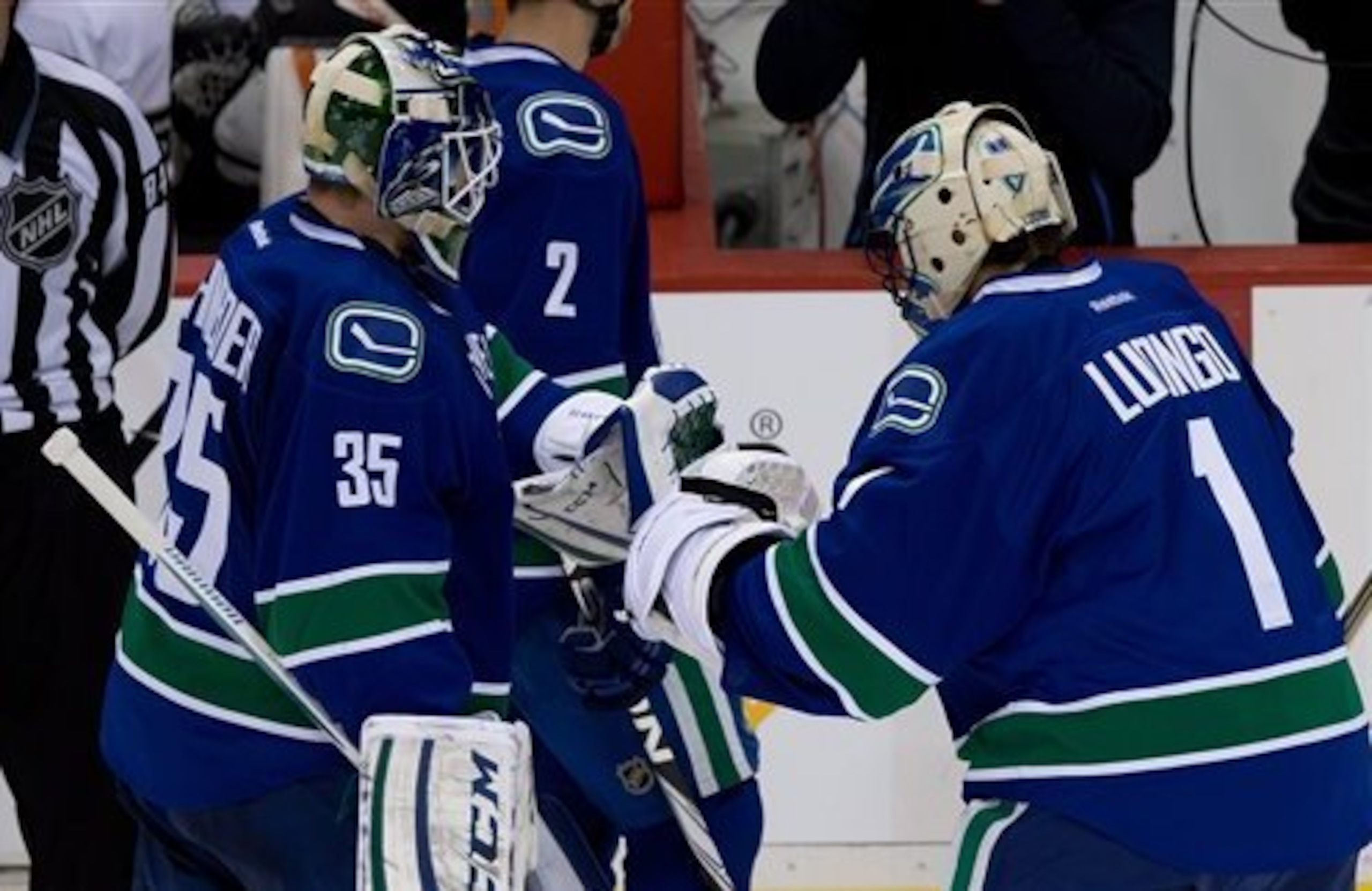 Vancouver Canucks' goalie Roberto Luongo, right, comes off the bench to replace goalie Cory Schneider after Schneider allowed a five goals to the Anaheim Ducks during second period NHL hockey action in Vancouver on Saturday, January 19, 2013. THE CANADIAN