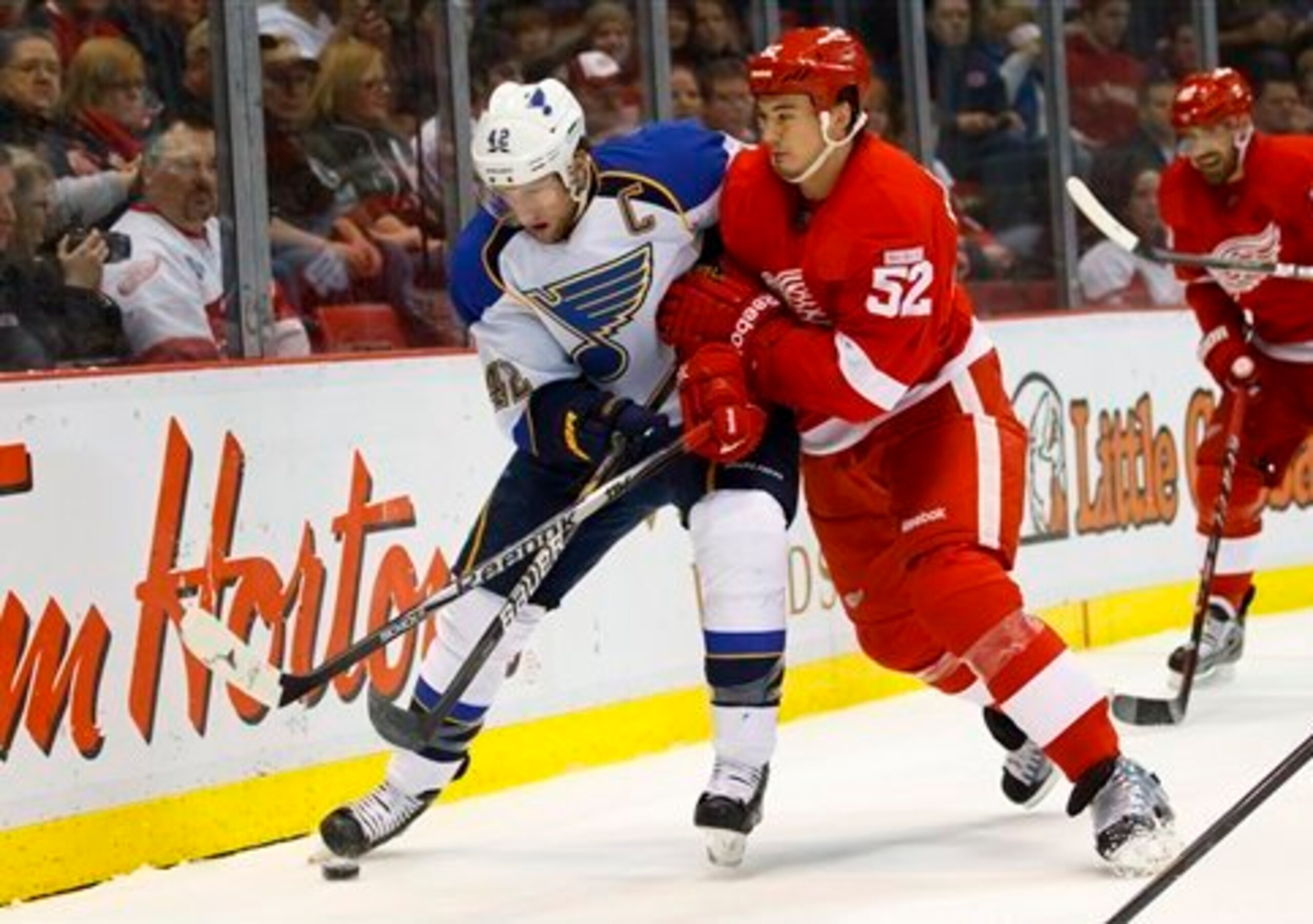 St. Louis Blues center David Backes (42) and Detroit Red Wings defenseman Jonathan Ericsson (52), of Sweden, battle for the puck in the first period of an NHL hockey game in Detroit, Saturday, Dec. 31, 2011. (AP Photo/Rick Osentoski)