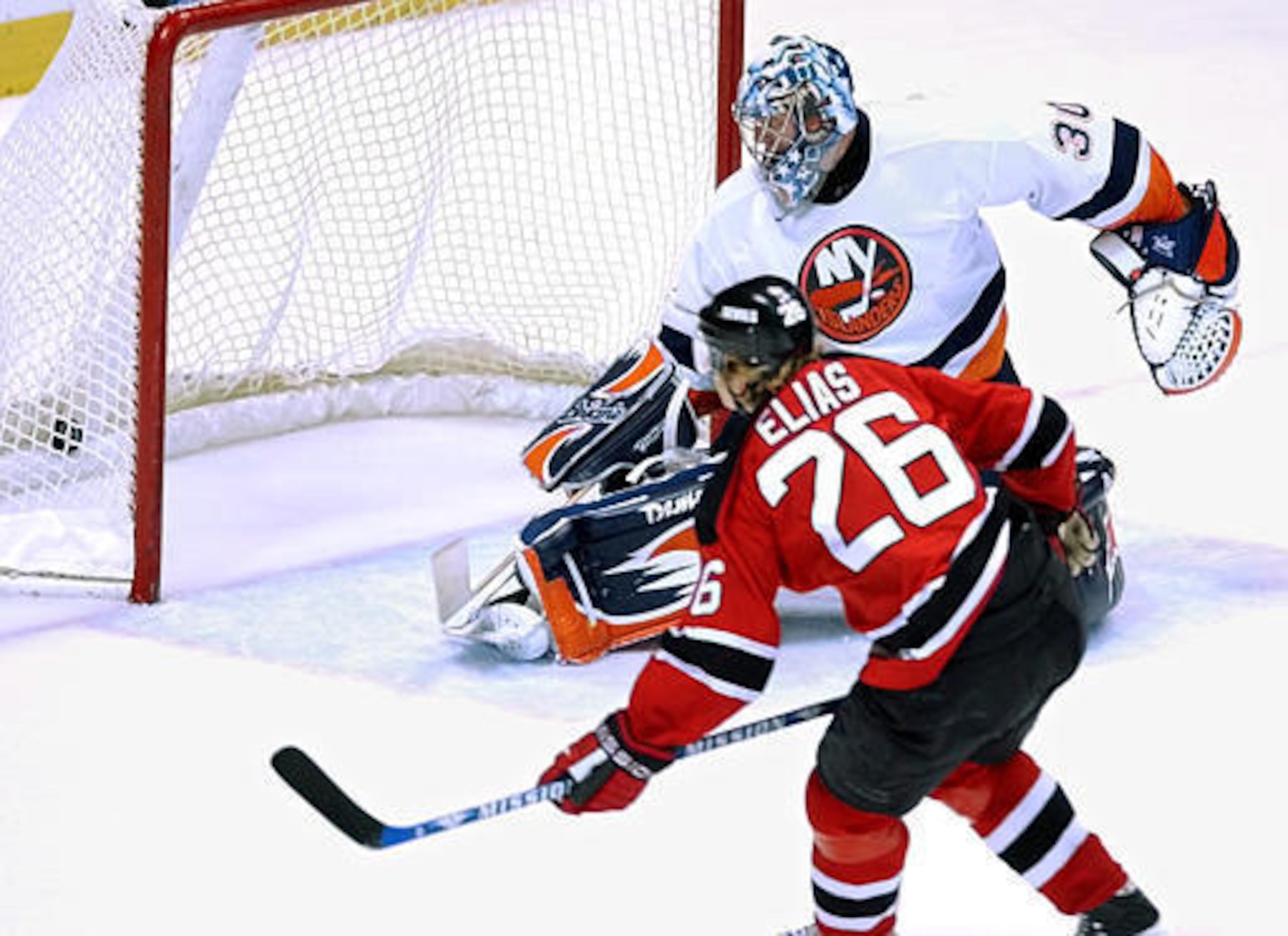 New Jersey Devils' Patrik Elias (26), of the Czech Republic, puts the puck into the net past New York Islanders goaltender Garth Snow for the winning goal in overtime Wednesday night, Dec. 10, 2003, in East Rutherford, N.J. The Devils won 1-0 in overtime.