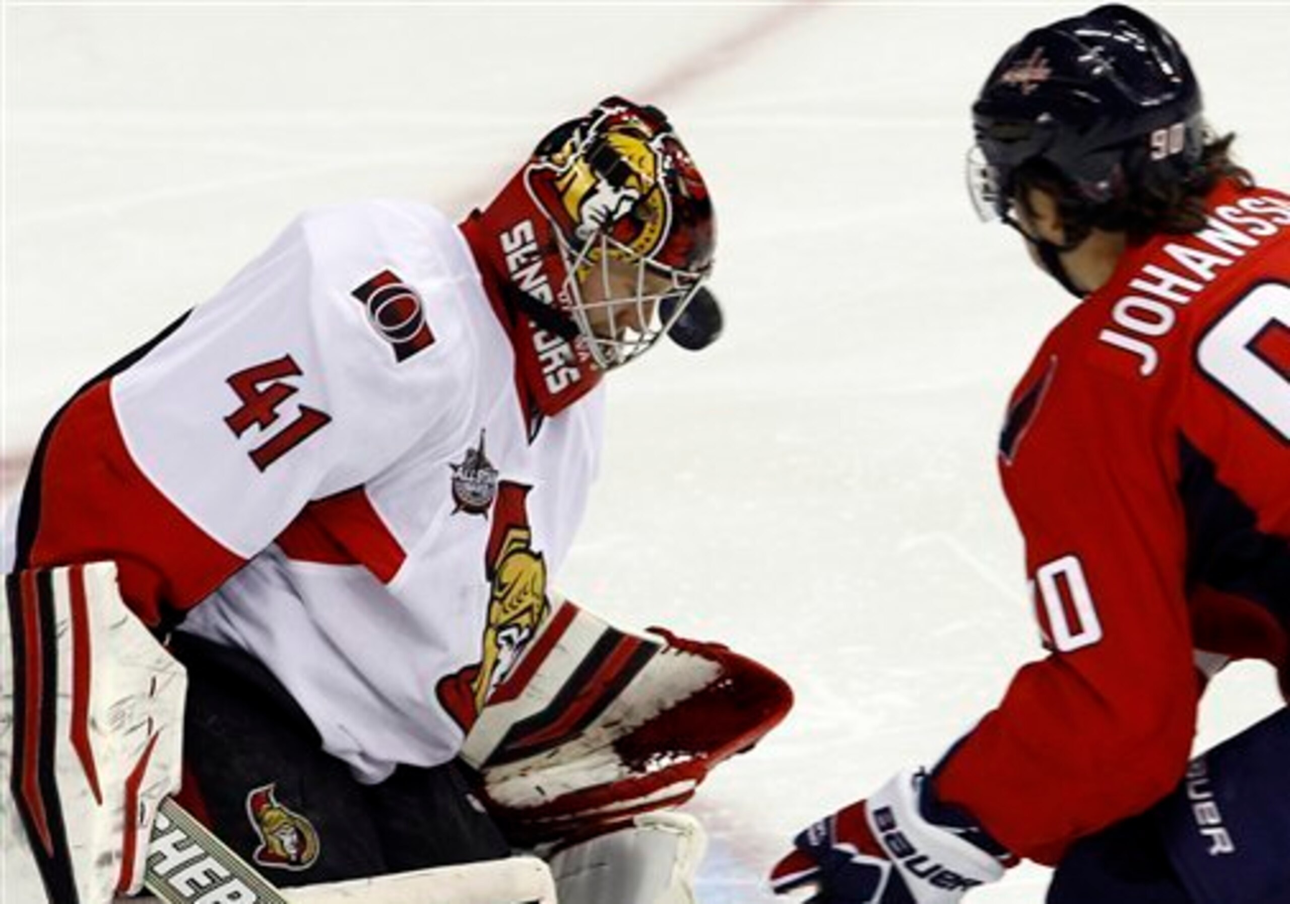Washington Capitals center Marcus Johansson (90), of Sweden, watches as Ottawa Senators goalie Craig Anderson (41) deflects a shot off his facemask during the first period of an NHL hockey game in Washington, Saturday, Dec. 3, 2011. (AP Photo/Ann Heisenfe
