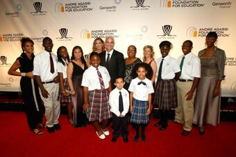 Andre Agassi surrounded by children at fundraiser for education.