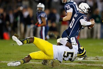 EAST HARTFORD, CT - SEPTEMBER 21: Frank Clark #57 of the Michigan Wolverines gets a piece of Chandler Whitmer #10 of the Connecticut Huskies in the 4th quarter against the Connecticut Huskies at Rentschler Field on September 21, 2013 in East Hartford, Con