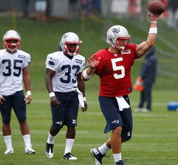 FOXBORO, MA - JULY 26: Tim Tebow #5 throws as George Winn #35 and Leon Washington #33 watch the action the first day of New England Patriots Training Camp at Gillette Stadium on July 26, 2013 in Foxboro, Massachusetts. (Photo by Jim Rogash/Getty Images)